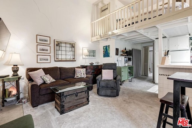 carpeted living room with a high ceiling