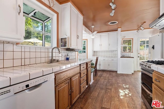 kitchen with sink, white appliances, white cabinetry, tile counters, and dark hardwood / wood-style flooring