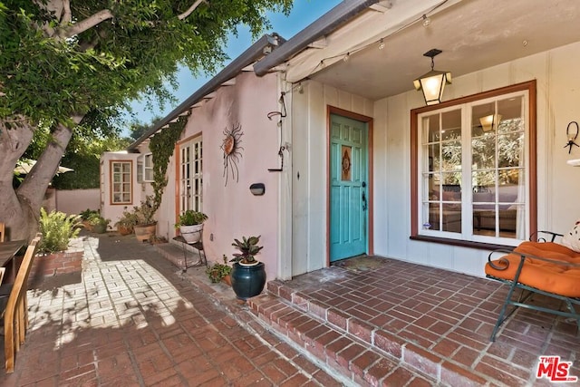 view of exterior entry featuring a patio area