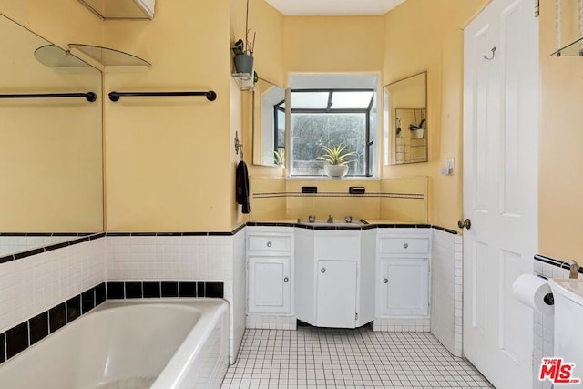 bathroom with tile patterned flooring, a tub, and sink