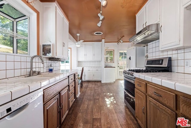 kitchen with dark hardwood / wood-style flooring, tile countertops, white cabinets, and white appliances