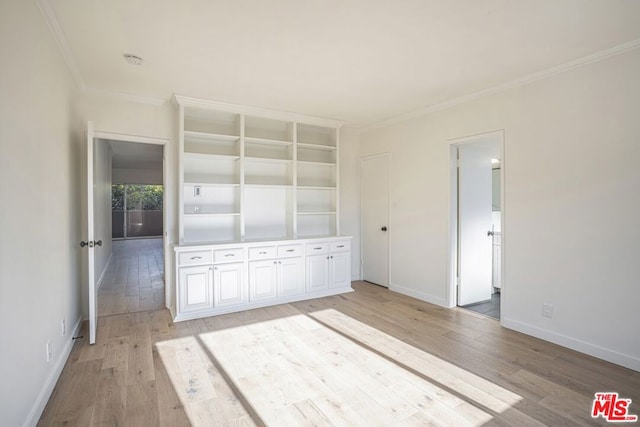 unfurnished bedroom with ornamental molding and light wood-type flooring