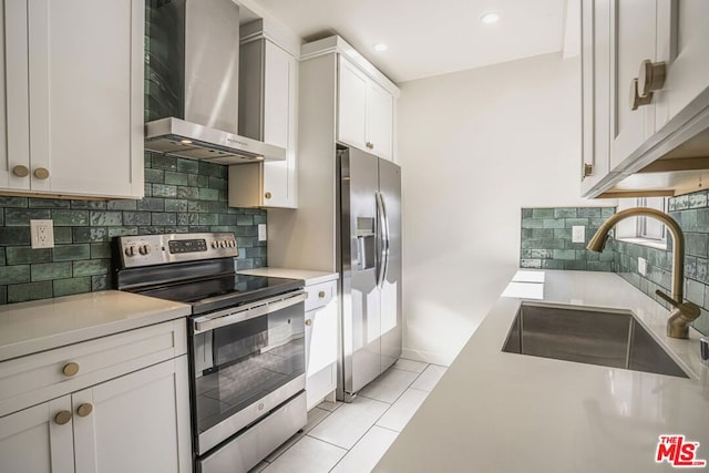 kitchen featuring stainless steel appliances, white cabinetry, sink, and wall chimney range hood