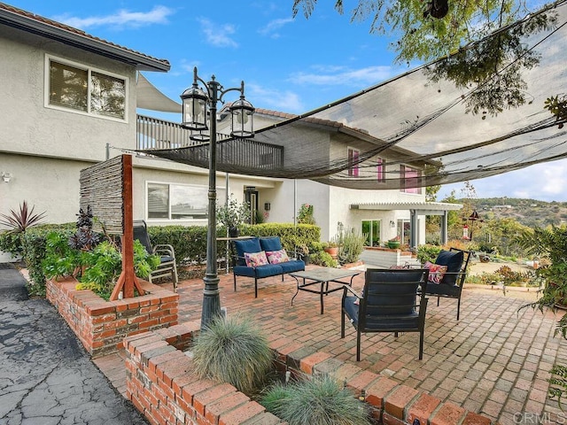 view of patio featuring an outdoor living space and a balcony