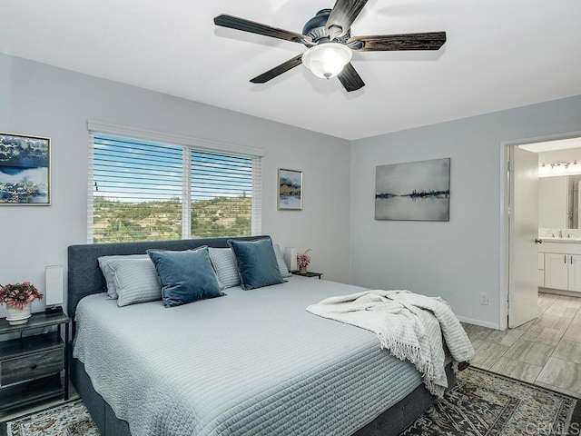 bedroom with sink, ensuite bath, and ceiling fan