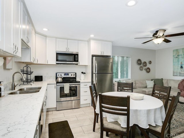 kitchen featuring stainless steel appliances, sink, and white cabinets