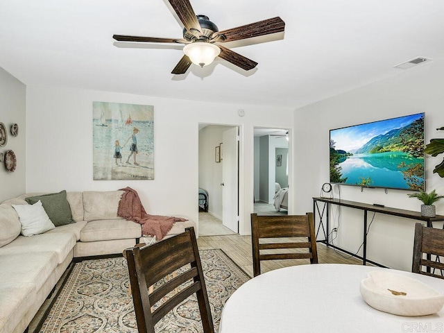 living room featuring ceiling fan and light hardwood / wood-style flooring