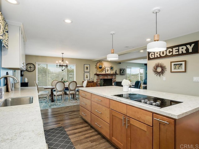 kitchen with sink, a chandelier, hanging light fixtures, black electric cooktop, and dark hardwood / wood-style flooring