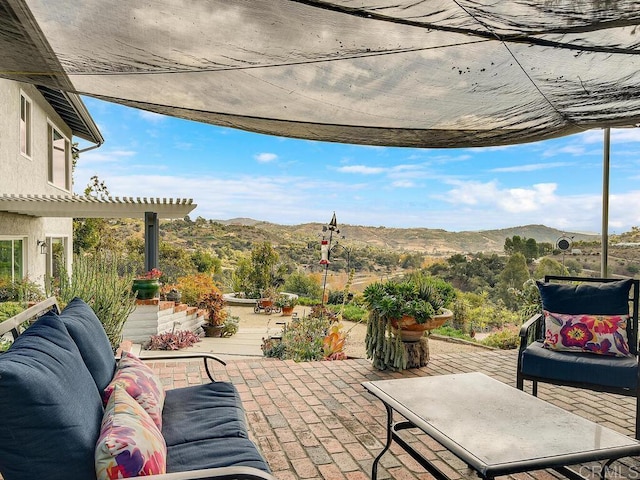 view of patio / terrace featuring an outdoor living space and a mountain view