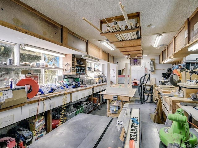 misc room with a workshop area, concrete floors, and a textured ceiling