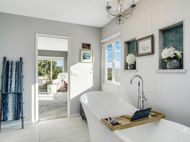 bathroom featuring an inviting chandelier, a tub to relax in, and tile patterned flooring