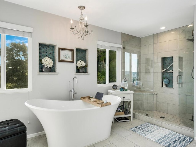 bathroom with a notable chandelier, plus walk in shower, plenty of natural light, and tile patterned floors