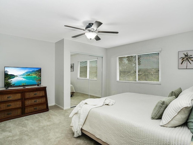 bedroom featuring ceiling fan, light colored carpet, and a closet