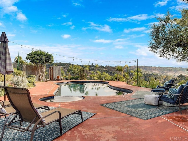 view of pool with a mountain view and a patio area