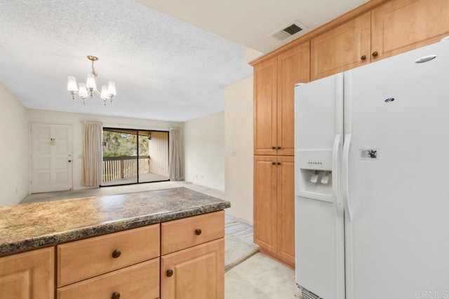 kitchen with decorative light fixtures, a textured ceiling, white fridge with ice dispenser, and a chandelier