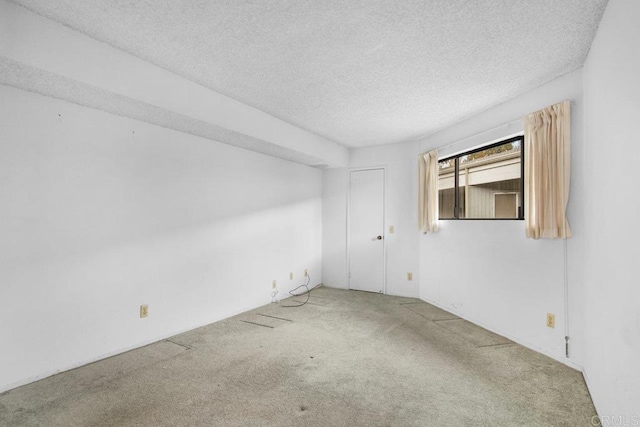 carpeted spare room with a textured ceiling