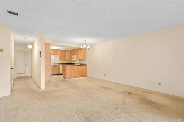 unfurnished living room featuring light carpet, a textured ceiling, and an inviting chandelier