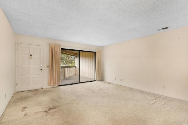 unfurnished room with light carpet and a textured ceiling