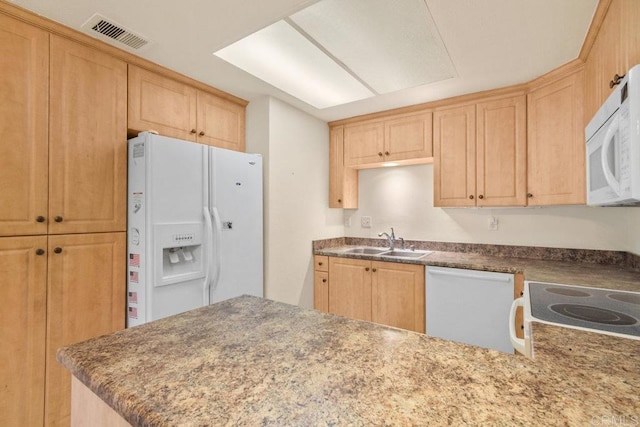 kitchen featuring light brown cabinetry, sink, white appliances, and kitchen peninsula