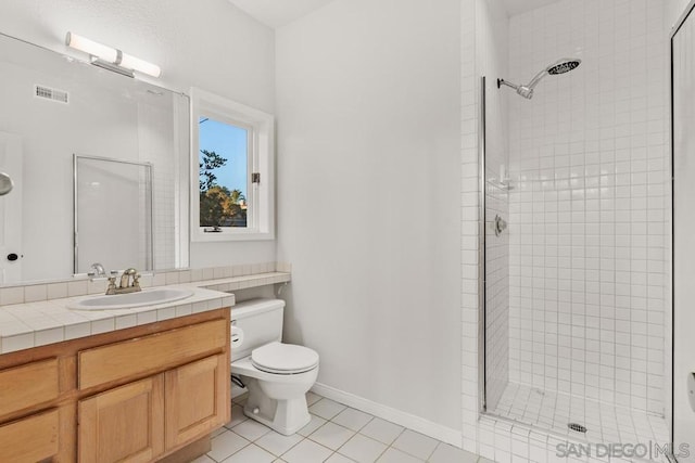 bathroom with tiled shower, vanity, and toilet