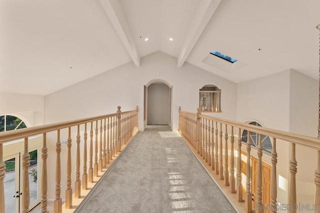 hall featuring carpet flooring and lofted ceiling with beams