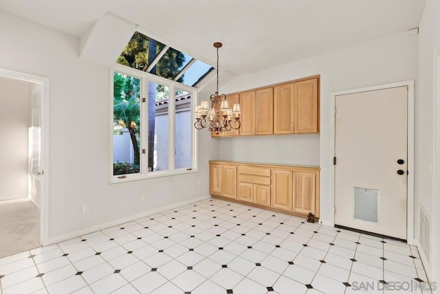 kitchen featuring an inviting chandelier, hanging light fixtures, vaulted ceiling with skylight, and light brown cabinets