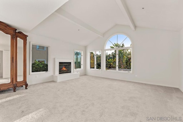 unfurnished living room featuring vaulted ceiling with beams and light colored carpet