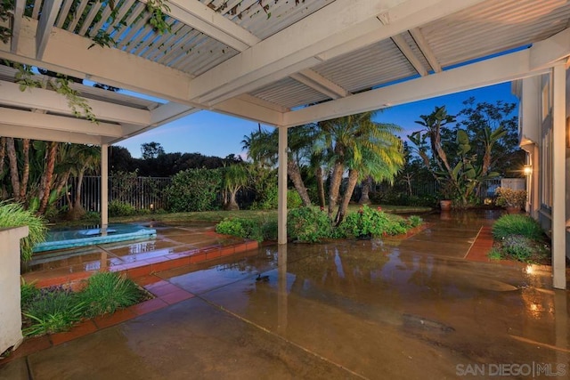 patio terrace at dusk featuring a pergola