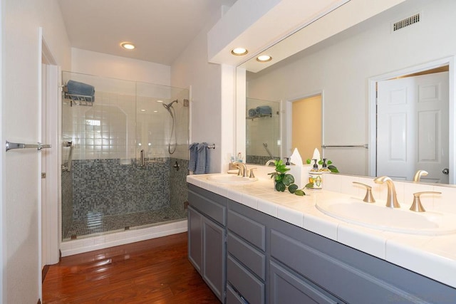 bathroom featuring walk in shower, vanity, and hardwood / wood-style flooring