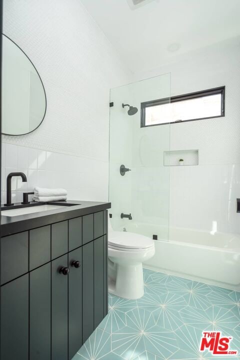 full bathroom with tasteful backsplash, vanity, toilet, and tiled shower / bath combo