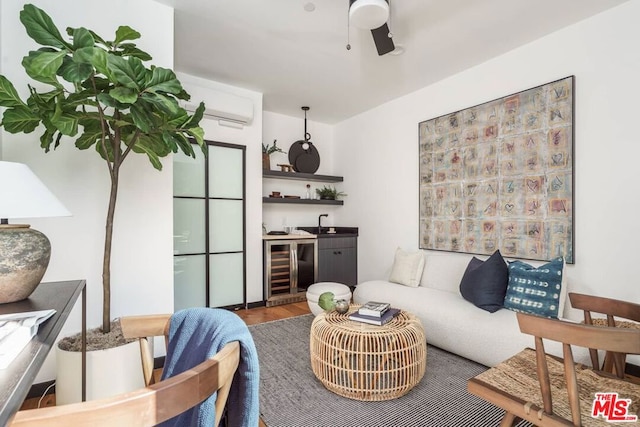 living room with wine cooler, hardwood / wood-style flooring, bar, ceiling fan, and a wall unit AC