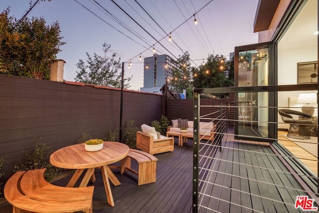 deck at dusk with an outdoor hangout area