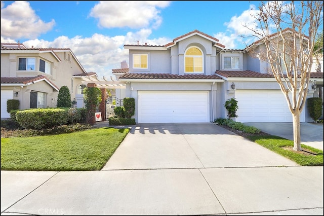 mediterranean / spanish house featuring a garage and a front lawn