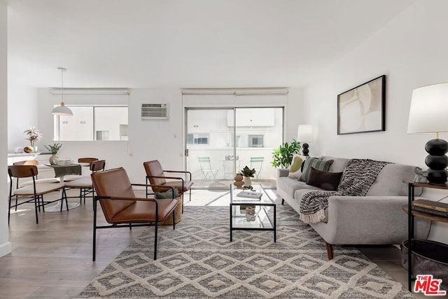 living room featuring hardwood / wood-style flooring and a wall mounted air conditioner