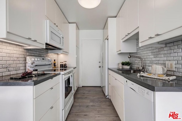 kitchen featuring sink, white appliances, backsplash, white cabinets, and light wood-type flooring