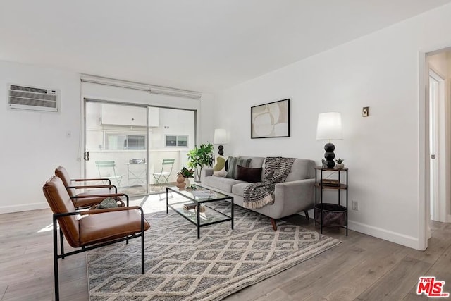 living room featuring a wall mounted air conditioner and light hardwood / wood-style floors