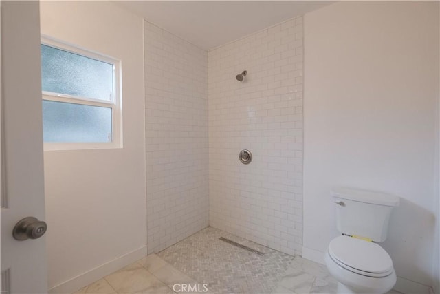 bathroom with toilet and a tile shower