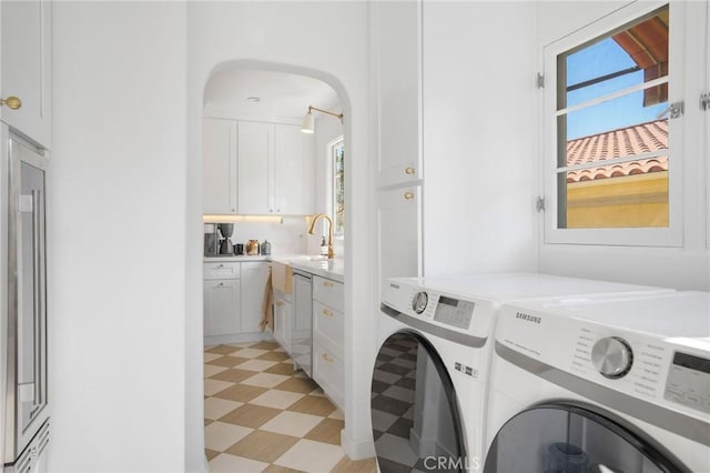 clothes washing area with washer and clothes dryer and sink