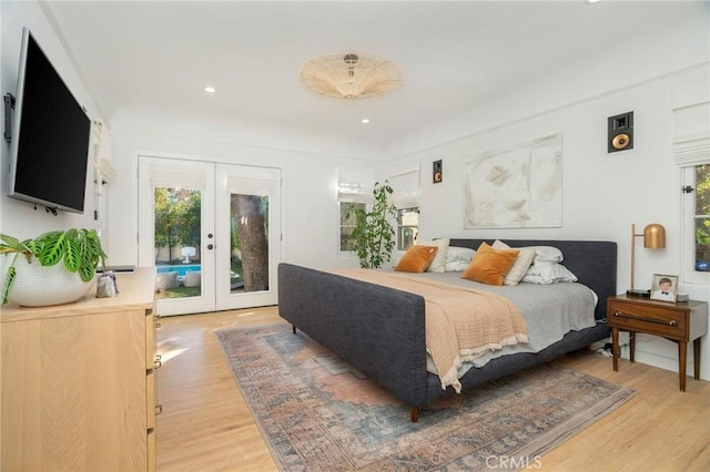 bedroom featuring access to outside, light hardwood / wood-style floors, and french doors