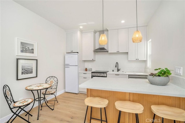 kitchen with a kitchen bar, white cabinetry, white refrigerator, kitchen peninsula, and stainless steel electric stove