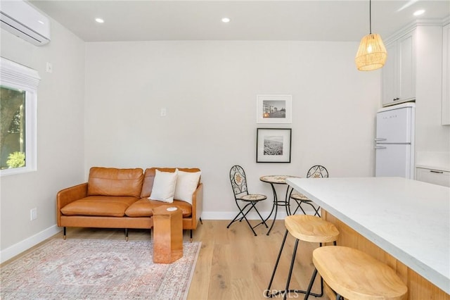 living room with light hardwood / wood-style floors and a wall mounted AC