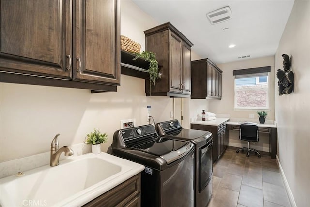 washroom featuring cabinets, separate washer and dryer, sink, and light tile patterned floors