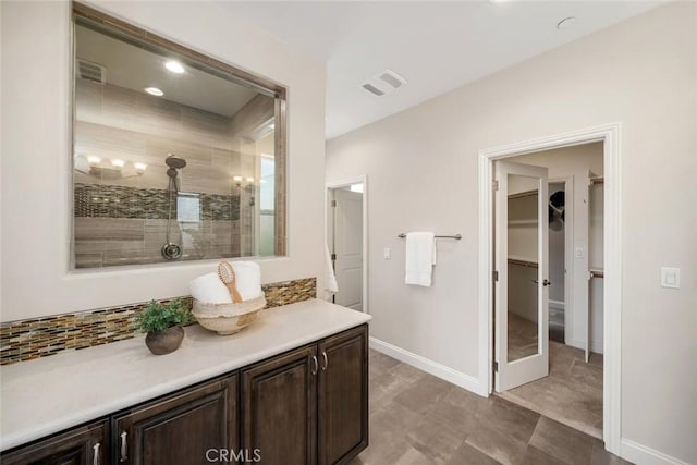 bathroom featuring a tile shower and vanity