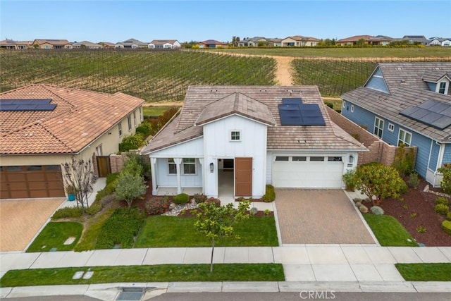 view of front facade featuring a garage and solar panels