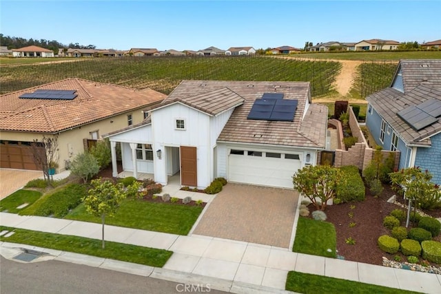 view of front of home with a garage and solar panels