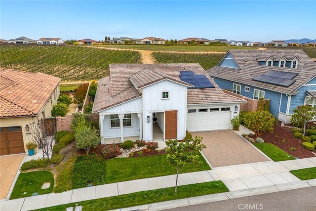 view of front facade with a garage and solar panels