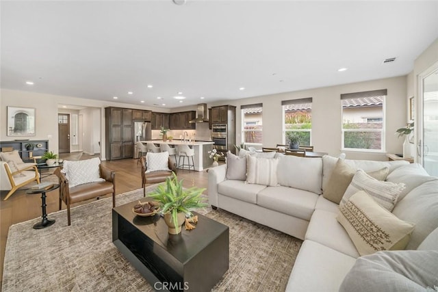 living room with sink and light hardwood / wood-style flooring