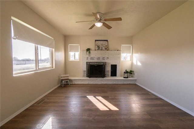 unfurnished living room with ceiling fan, dark wood-type flooring, and a fireplace