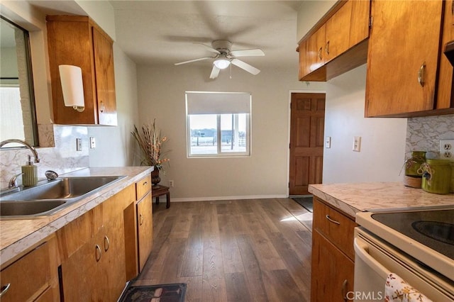 kitchen featuring white electric range oven, sink, dark hardwood / wood-style flooring, ceiling fan, and backsplash