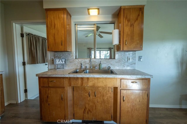 kitchen featuring tasteful backsplash, sink, dark wood-type flooring, and ceiling fan